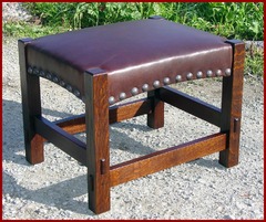 The same form with the addition of tacks.  Please see our model #100-T with tacks.  Gustav Stickley produced this footstool with and without tacks, he also produced this same form simplified without the arches and trough-tenons. We chose to offer the replica of the more desirable form, with and without tacks.